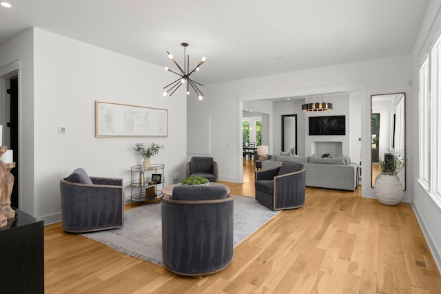 living room with a notable chandelier and light hardwood / wood-style floors