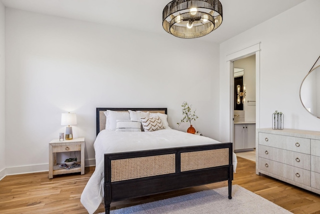 bedroom featuring light wood-type flooring and connected bathroom