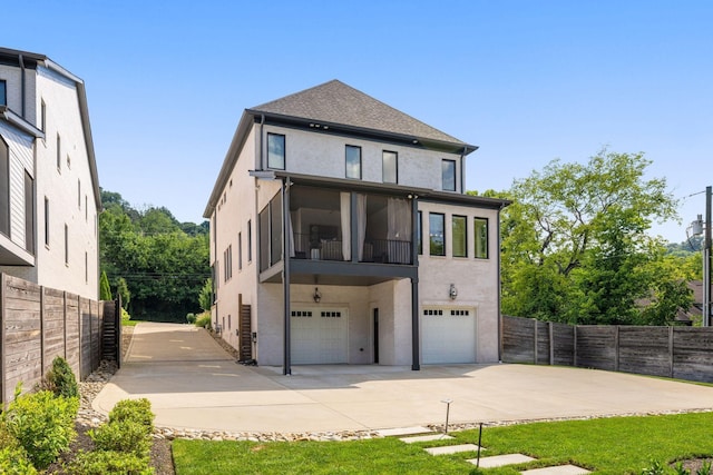 back of property featuring a garage and a sunroom