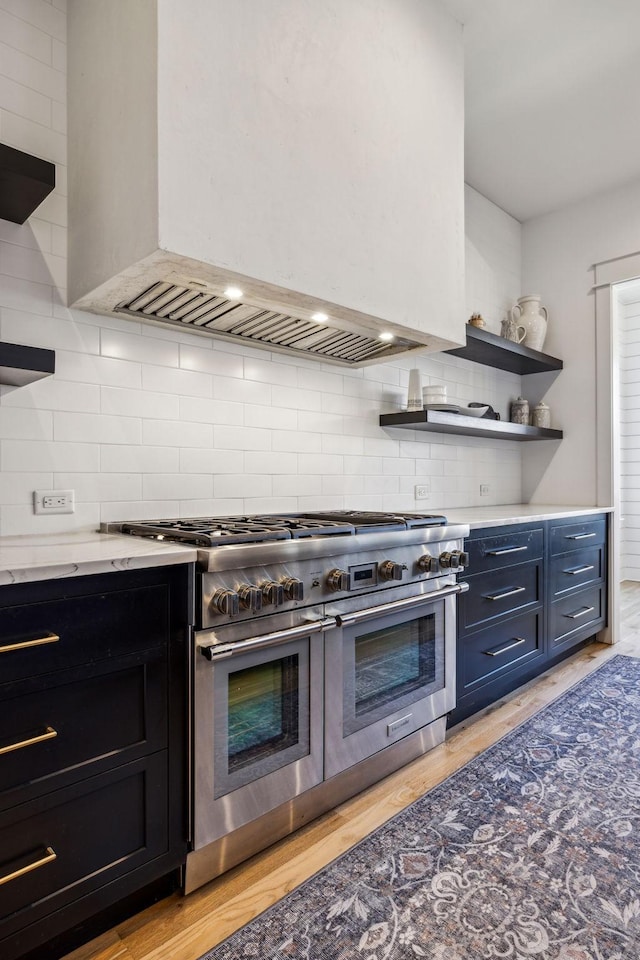 kitchen featuring light hardwood / wood-style floors, decorative backsplash, double oven range, and custom range hood