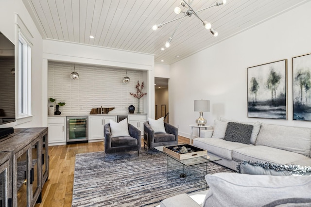 living room with light wood-type flooring, bar, beverage cooler, and wooden ceiling