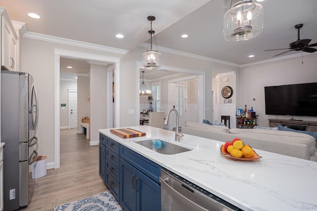 kitchen featuring appliances with stainless steel finishes, hanging light fixtures, blue cabinetry, sink, and white cabinetry