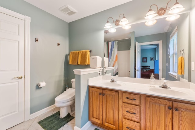 bathroom featuring toilet, vanity, and tile patterned flooring