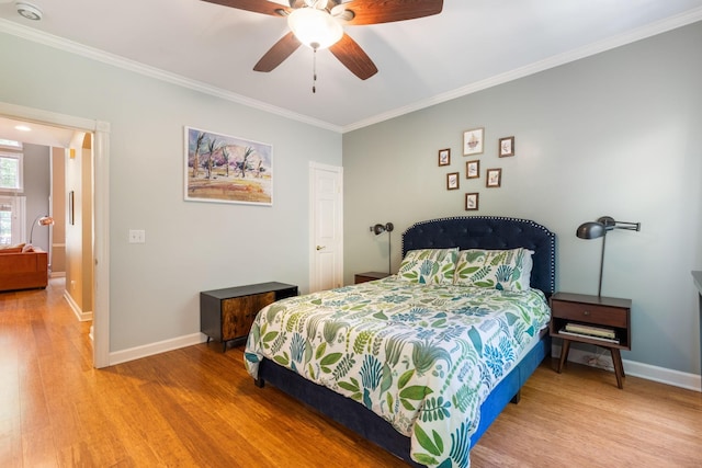 bedroom featuring hardwood / wood-style floors, crown molding, and ceiling fan