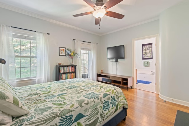 bedroom featuring ceiling fan, ensuite bath, light wood-type flooring, and crown molding