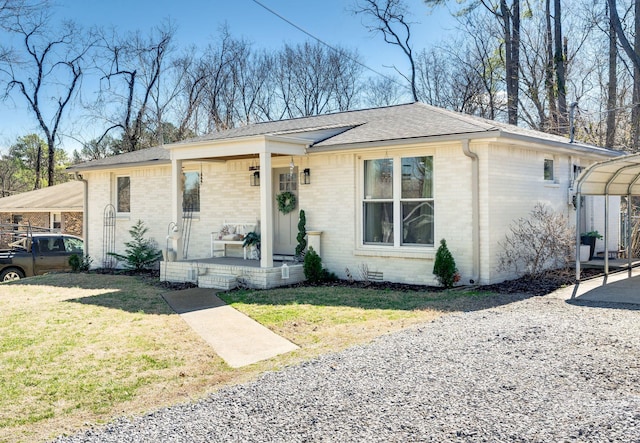 view of front of house with brick siding, a porch, a front yard, and a shingled roof