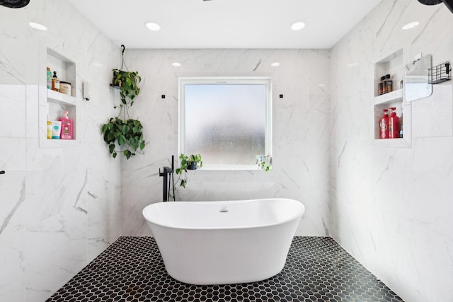 bathroom with tile walls and a bath