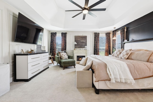 bedroom featuring light colored carpet and a raised ceiling