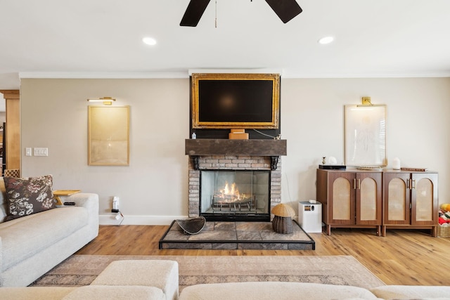 living room with hardwood / wood-style floors, ornamental molding, and a fireplace