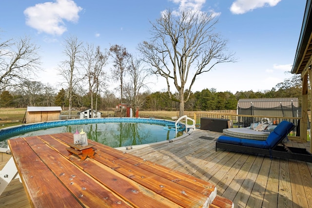 view of pool featuring a storage shed and a wooden deck