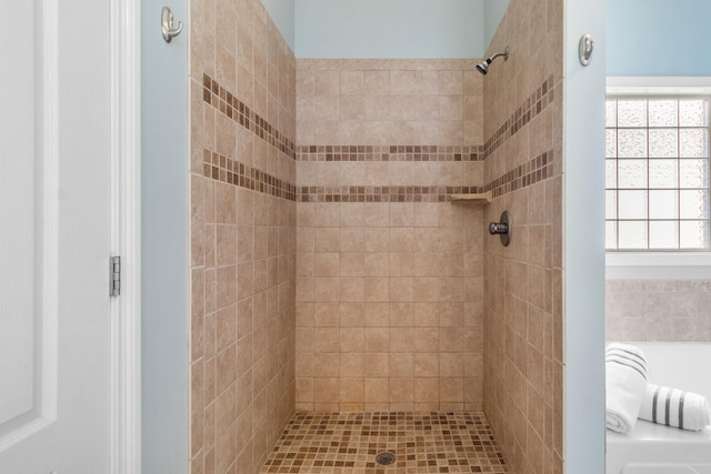 bathroom with tiled shower and plenty of natural light