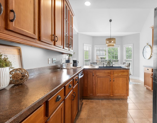 kitchen with dishwasher, decorative light fixtures, light tile patterned floors, sink, and kitchen peninsula