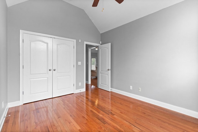 unfurnished bedroom featuring a closet, lofted ceiling, ceiling fan, and wood-type flooring