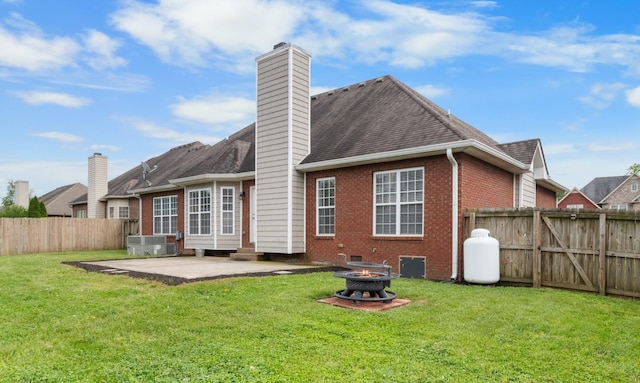 back of house featuring an outdoor fire pit, a patio, a yard, and central AC