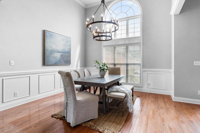 dining area featuring ornamental molding, a notable chandelier, and light hardwood / wood-style flooring