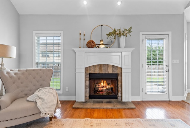 living area with a tile fireplace and light hardwood / wood-style flooring