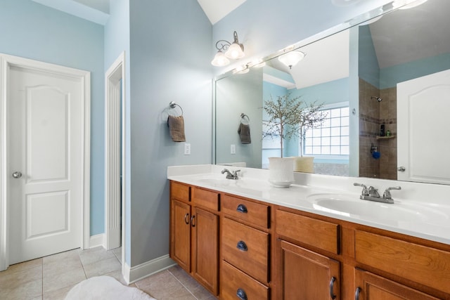 bathroom with a tile shower, vanity, and tile patterned flooring