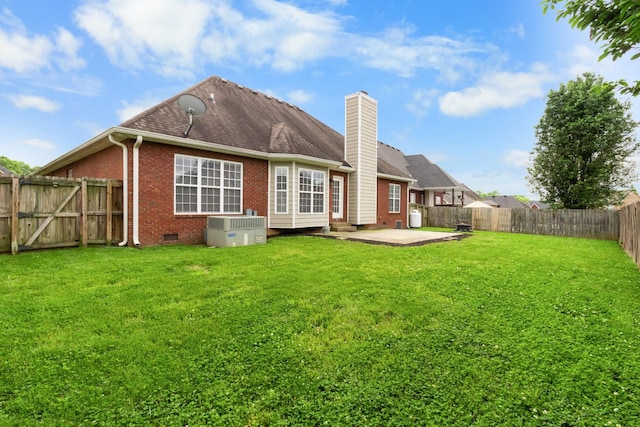 rear view of house with central AC unit, a lawn, and a patio area