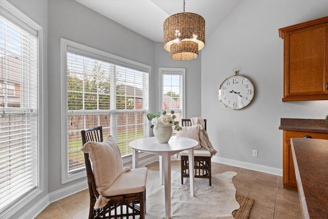 dining area with vaulted ceiling, an inviting chandelier, and light tile patterned floors