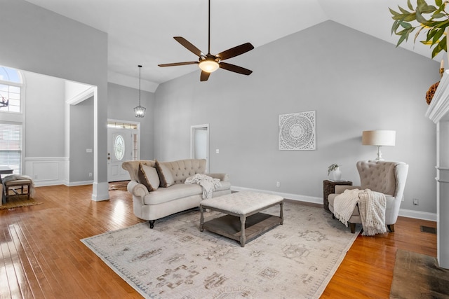 living room featuring ceiling fan, high vaulted ceiling, and wood-type flooring