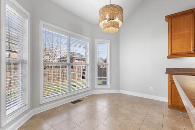 unfurnished dining area featuring lofted ceiling, light tile patterned flooring, and an inviting chandelier