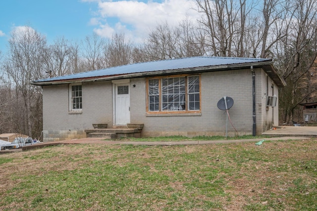 ranch-style house featuring metal roof, brick siding, a front lawn, and crawl space