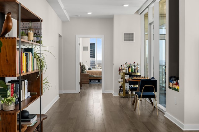 hallway featuring recessed lighting, baseboards, visible vents, and dark wood-style flooring