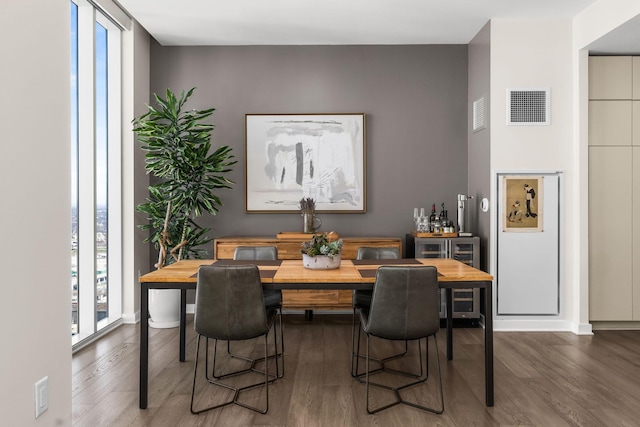 dining area featuring wood finished floors, visible vents, and baseboards