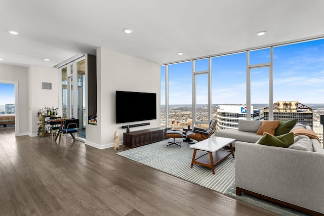 living room with recessed lighting, expansive windows, baseboards, and wood finished floors