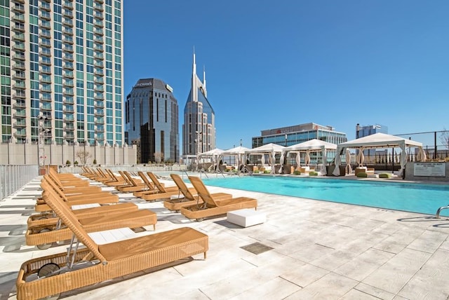 pool with a gazebo, a patio area, and a view of city