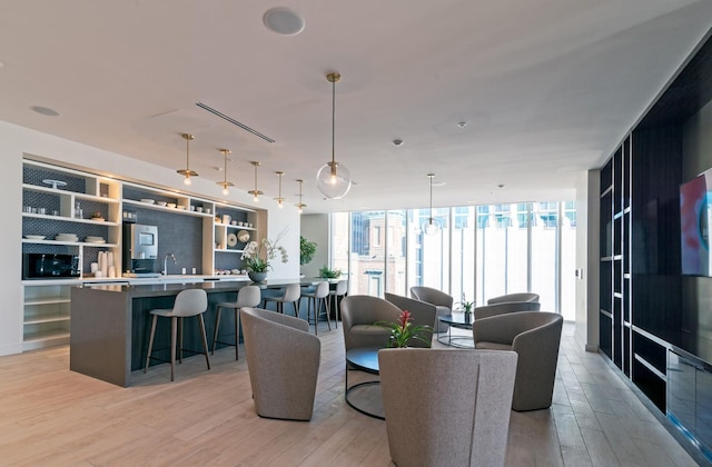 living area with light wood-type flooring and floor to ceiling windows