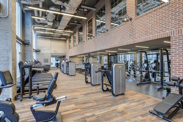 workout area with a high ceiling and wood finished floors