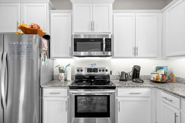 kitchen with appliances with stainless steel finishes, light stone countertops, and white cabinets