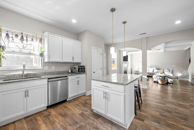 kitchen with white cabinetry, sink, pendant lighting, and stainless steel dishwasher