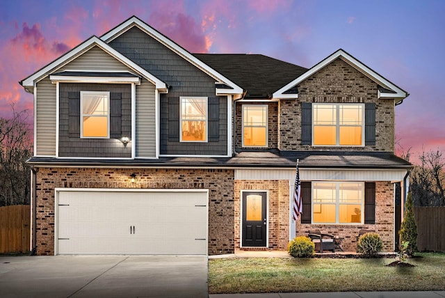 view of front of property featuring driveway, brick siding, an attached garage, and fence