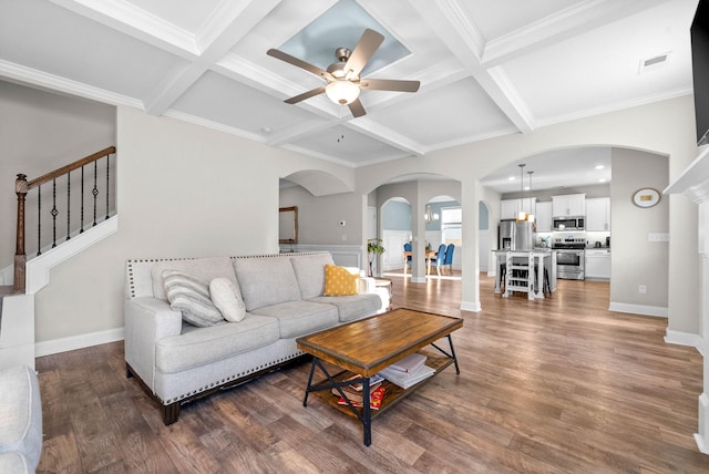 living room featuring ornamental molding, ceiling fan, coffered ceiling, dark hardwood / wood-style flooring, and beamed ceiling