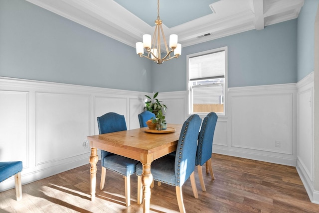 dining room with dark hardwood / wood-style flooring, a chandelier, and crown molding