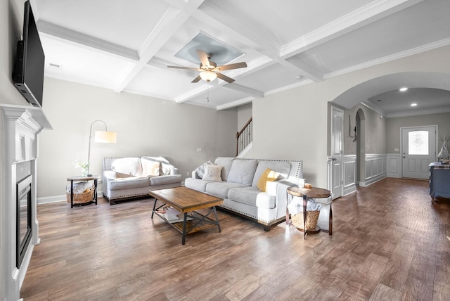 living room featuring coffered ceiling, crown molding, dark hardwood / wood-style flooring, ceiling fan, and beam ceiling