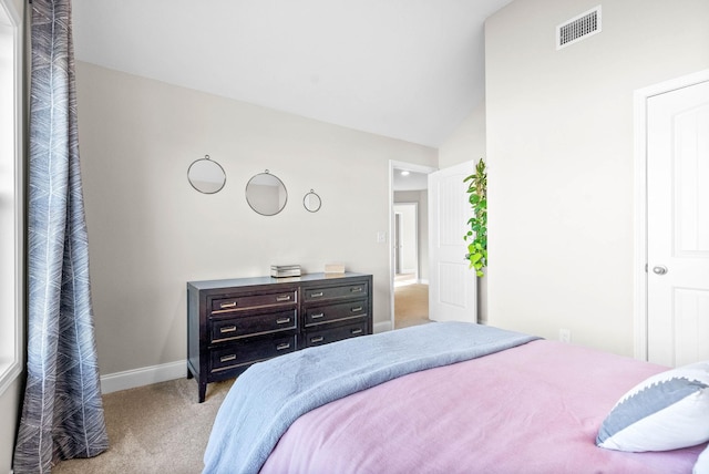 bedroom with vaulted ceiling and light colored carpet