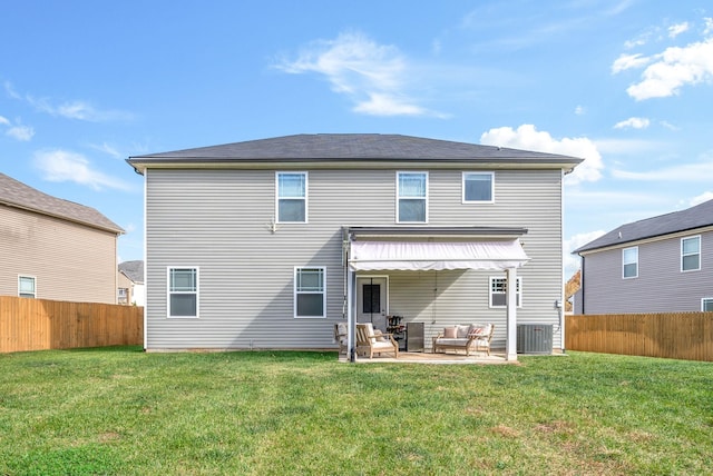 back of property with a patio area, an outdoor living space, and a lawn