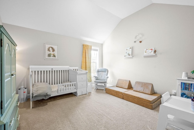 carpeted bedroom featuring a crib and lofted ceiling