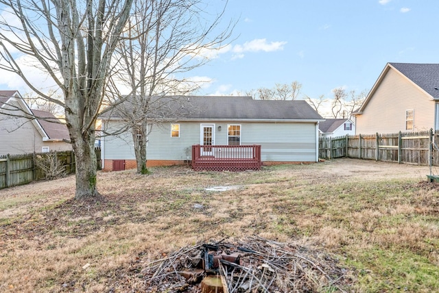 rear view of house featuring a lawn and a wooden deck