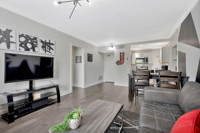 living room featuring hardwood / wood-style flooring and crown molding