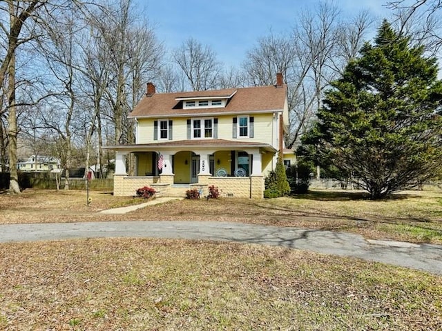 view of front of house with covered porch and a front yard