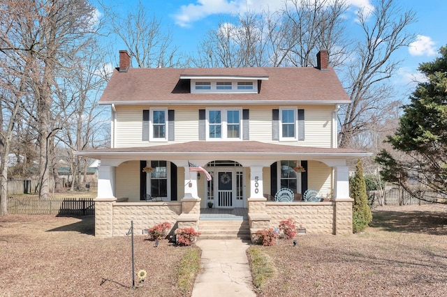 traditional style home with a porch, a chimney, and fence