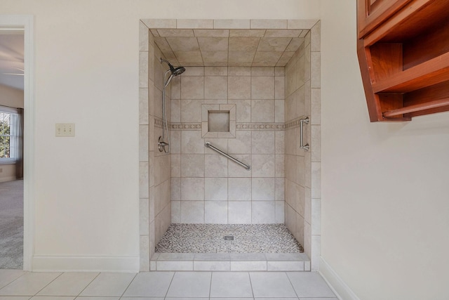 bathroom with tiled shower and tile patterned flooring