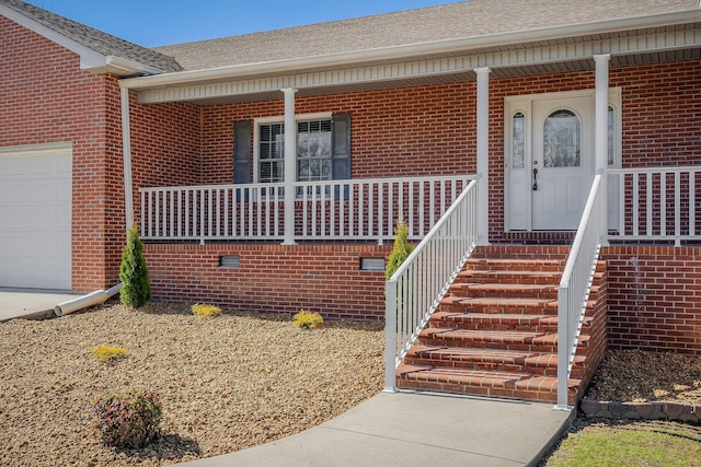 view of exterior entry with covered porch and a garage