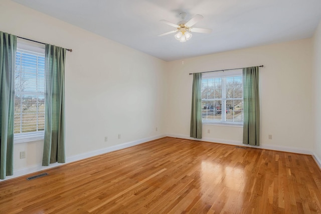 empty room with ceiling fan and light hardwood / wood-style floors