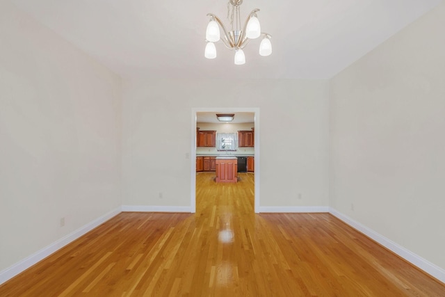 unfurnished dining area with light hardwood / wood-style floors and an inviting chandelier