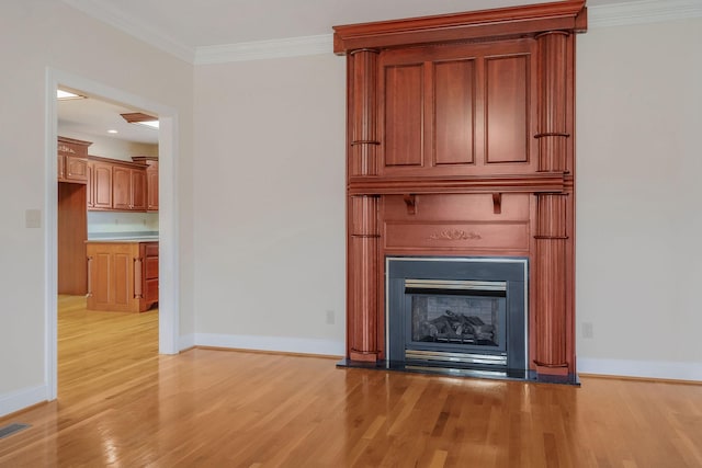 unfurnished living room with a fireplace, ornamental molding, and light hardwood / wood-style floors